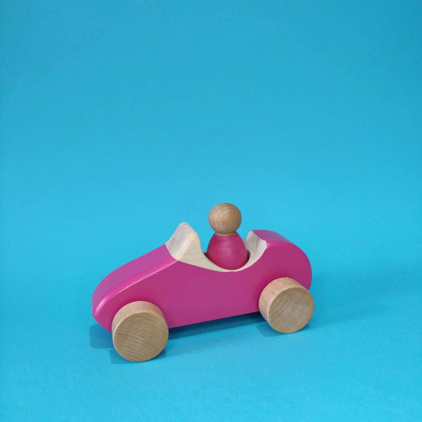 coche de madera con muñeco montessori rosa