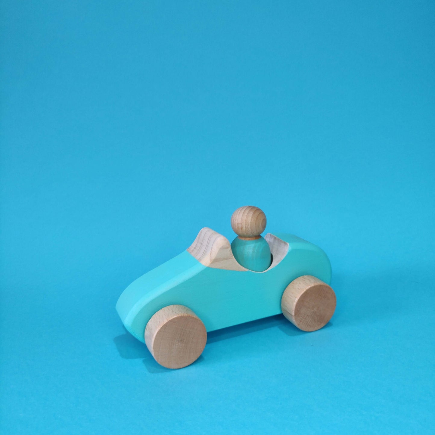 coche de madera con muñeco montessori