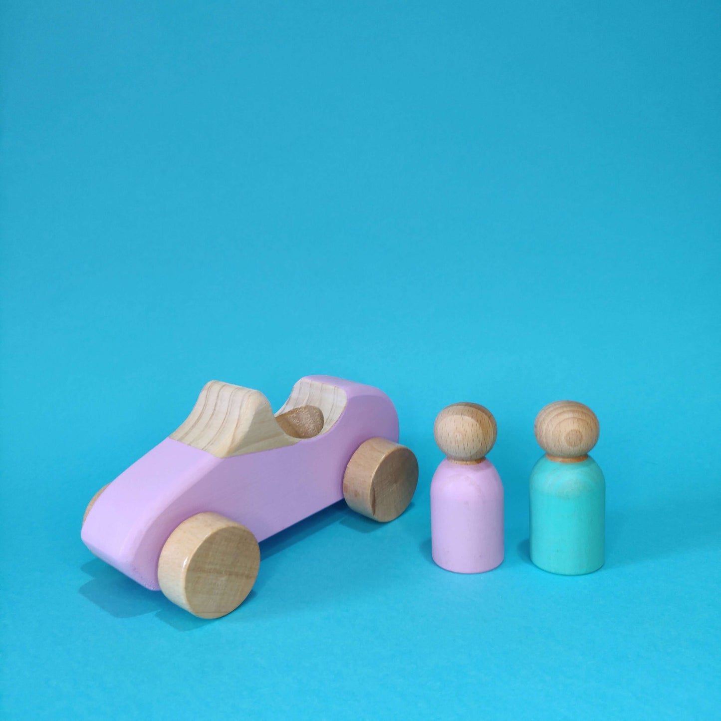 coche de madera con muñeco montessori lila y dos muñecos